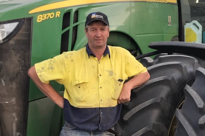 A man standing in front of a tractor