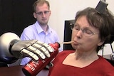 Cathy Hutchinson makes a robotic arm grasp a flask using only her thoughts.
