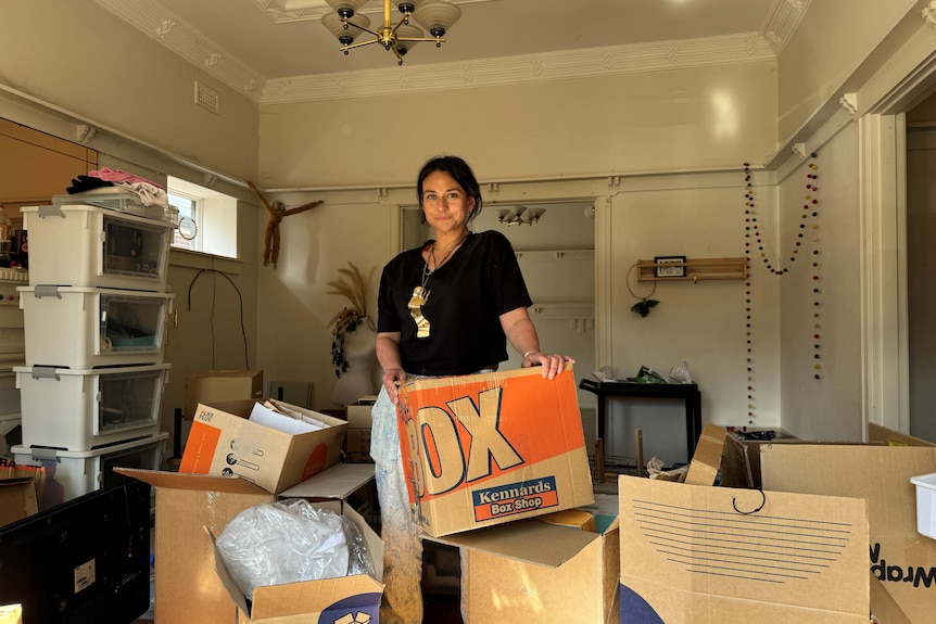 a woman holding moving boxes