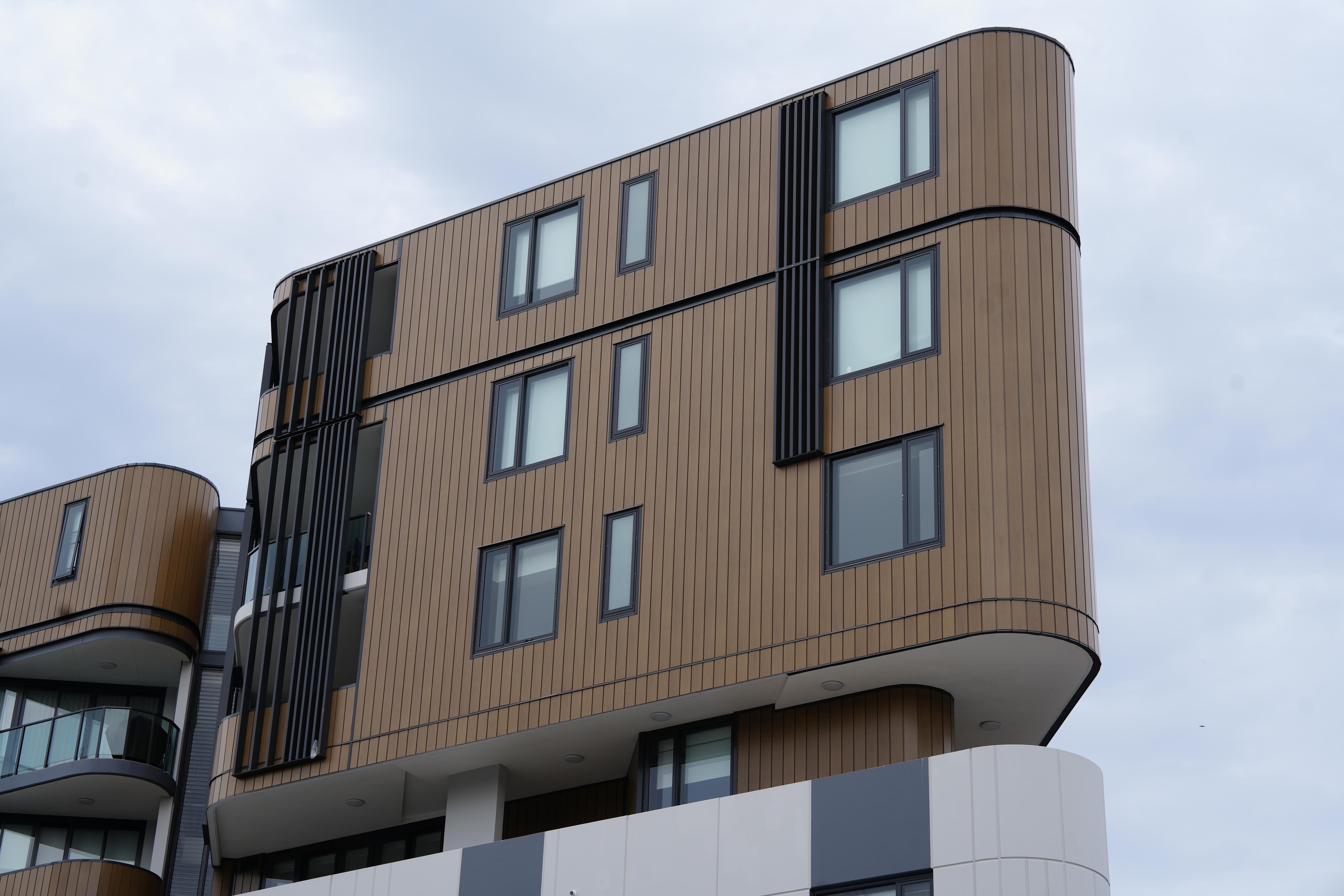 The top floor of a modern, dark apartment block.