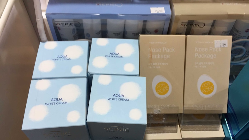Skin whitening creams in boxes on a shelf.