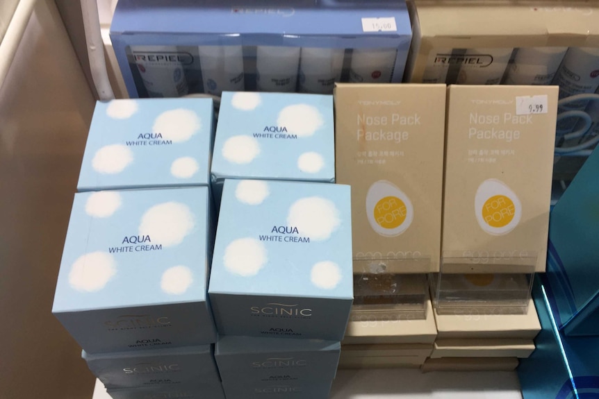 Skin whitening creams in boxes on a shelf.