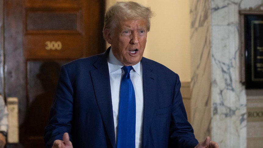 Donald Trump in a blue suit and tie outside a courtroom