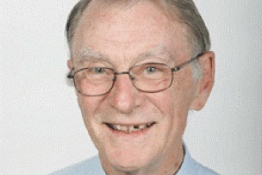 Man in a tie smiles at the camera.