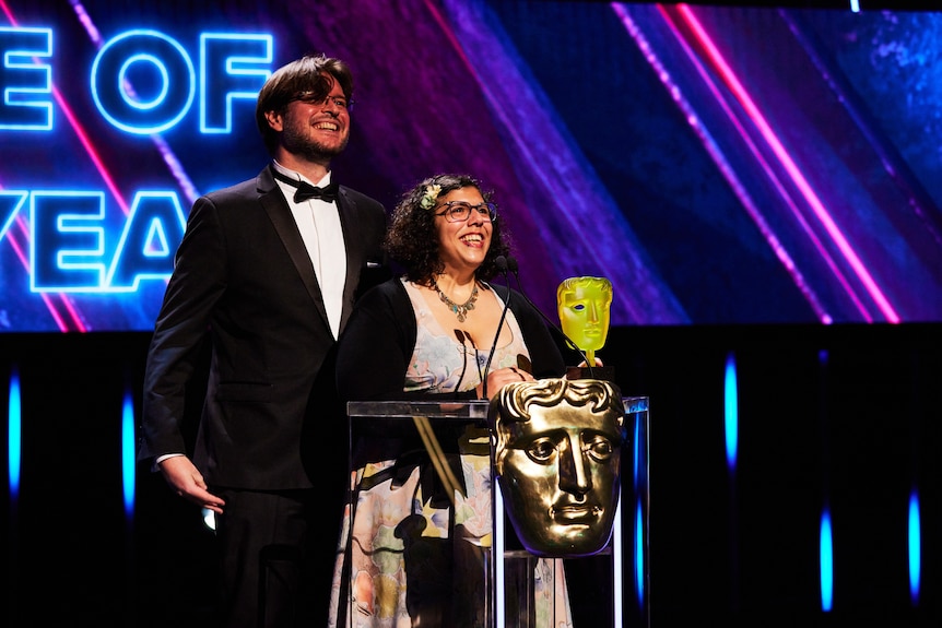 Tim Dawson and Wren Brier on stage at the BAFTAs after winning. 