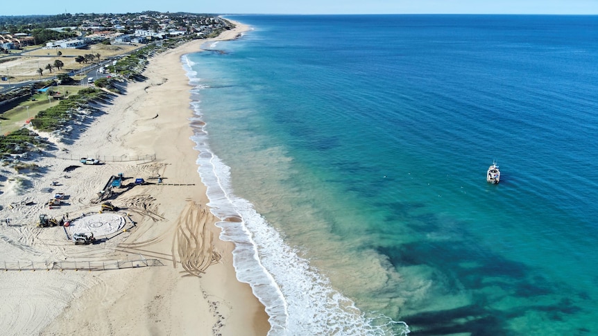 A drone shot over Bunbury's Back where you can see blue water, white sand, dunes and the Airwave being set up
