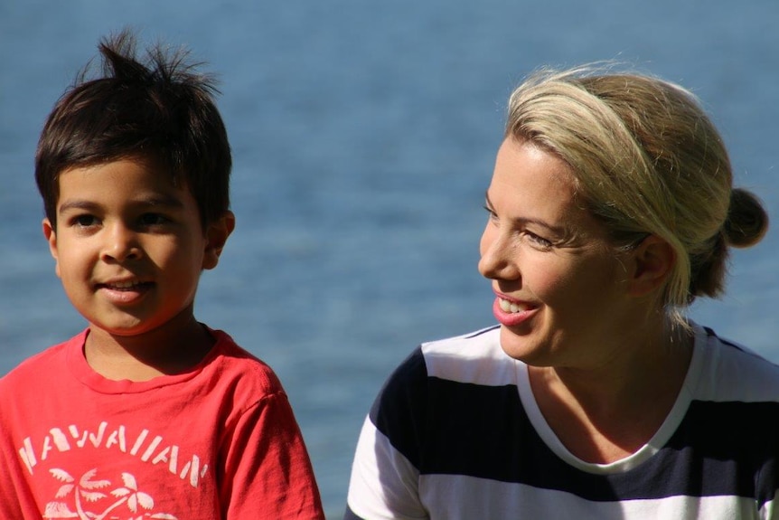 A headshot of a woman in a blue and white striped dress and a boy in a red t-shirt.