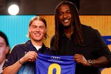 Harley Reid and Nic Naitanui hold up the West Coast Eagles' number nine guernsey at the AFL draft.