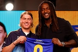 Harley Reid and Nic Naitanui hold up the West Coast Eagles' number nine guernsey at the AFL draft.