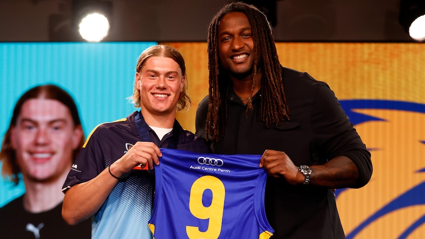 Harley Reid and Nic Naitanui hold up the West Coast Eagles' number nine guernsey at the AFL draft.