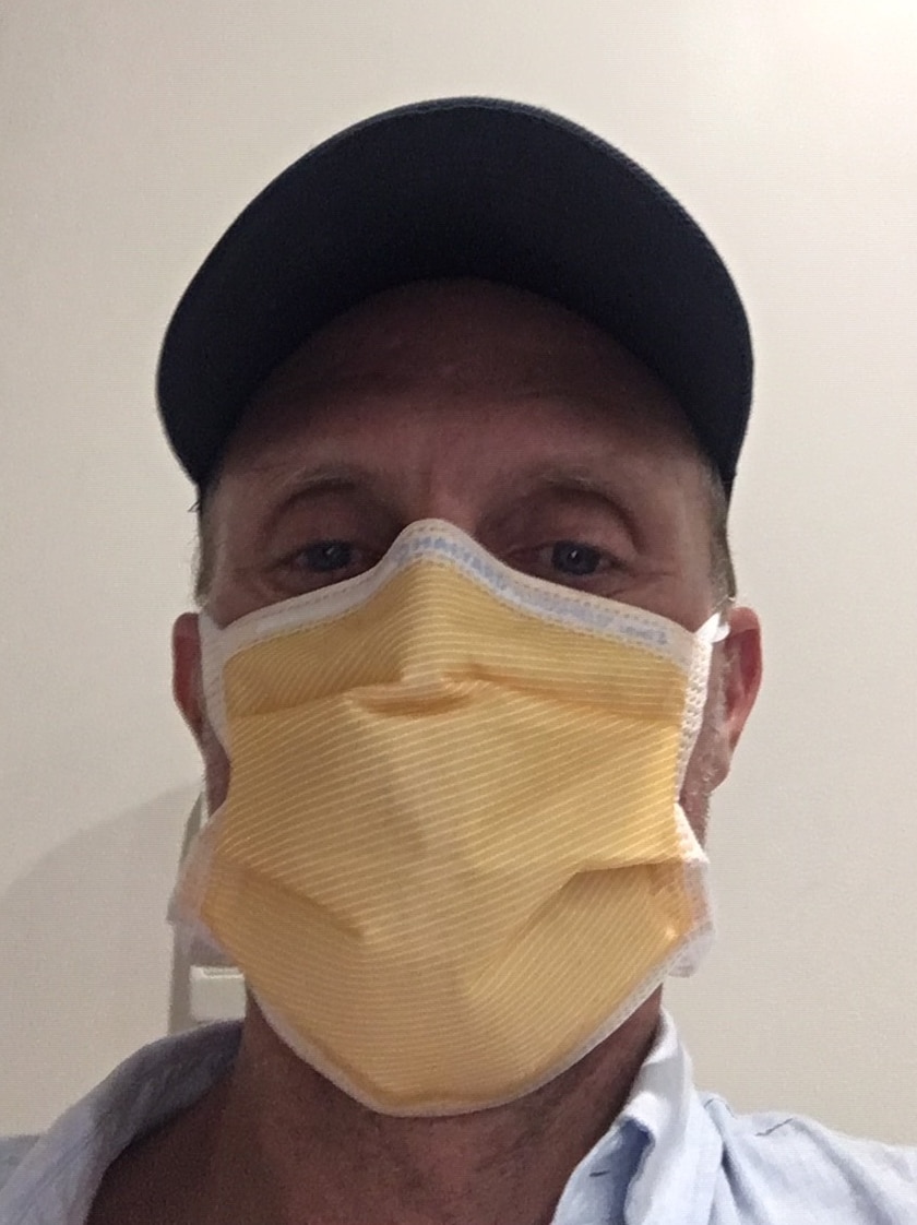 Close-up of man's face wearing a surgical mask.