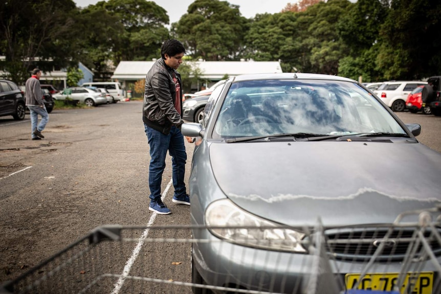 A man unlocks a car door