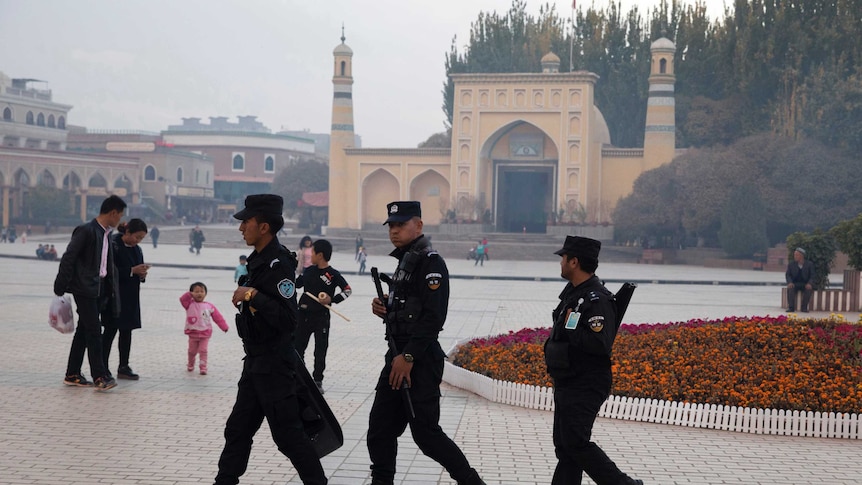 Uighur security personnel patrol in Kashgar