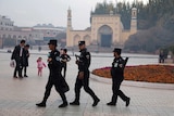 Uighur security personnel patrol in Kashgar