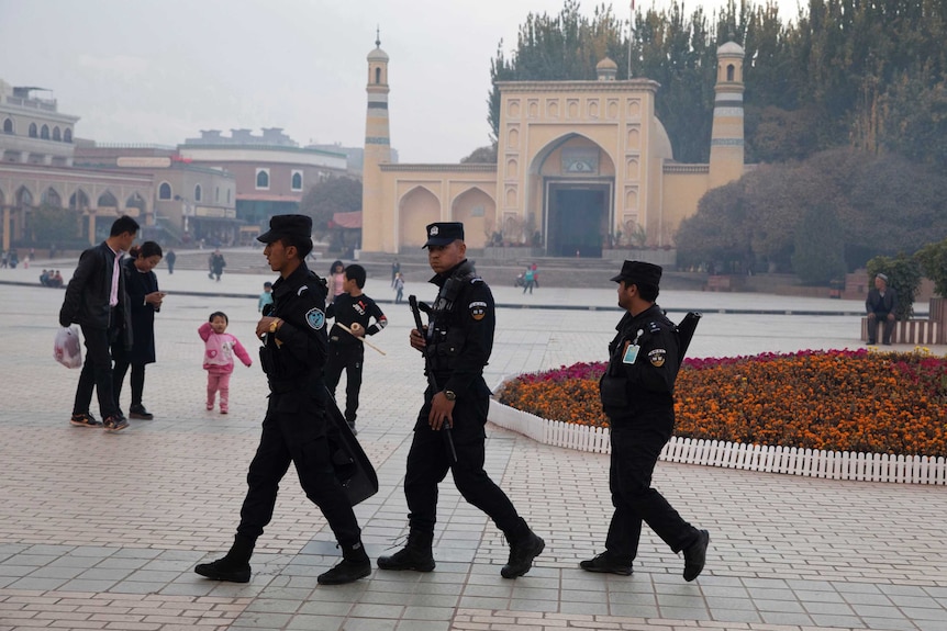 Uighur security personnel patrol in Kashgar