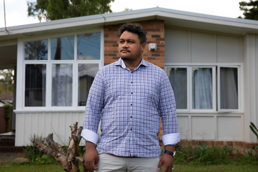 Steven Maaelopa standing in front of suburban home.