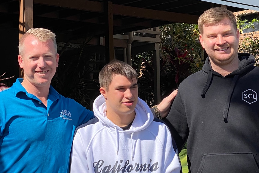 Three men standing side-by-side.