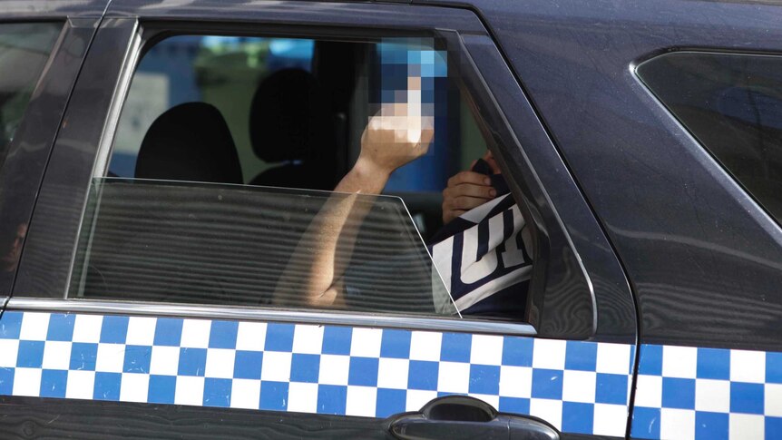 A member of Brothers 4 Life gestures to the media after being arrested in Auburn.