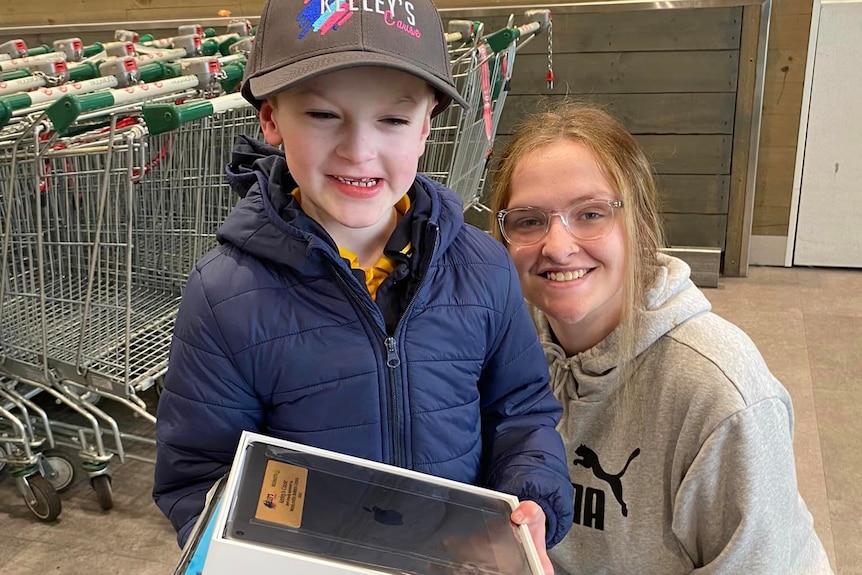 Keeley Murphy with young boy receiving ipad 
