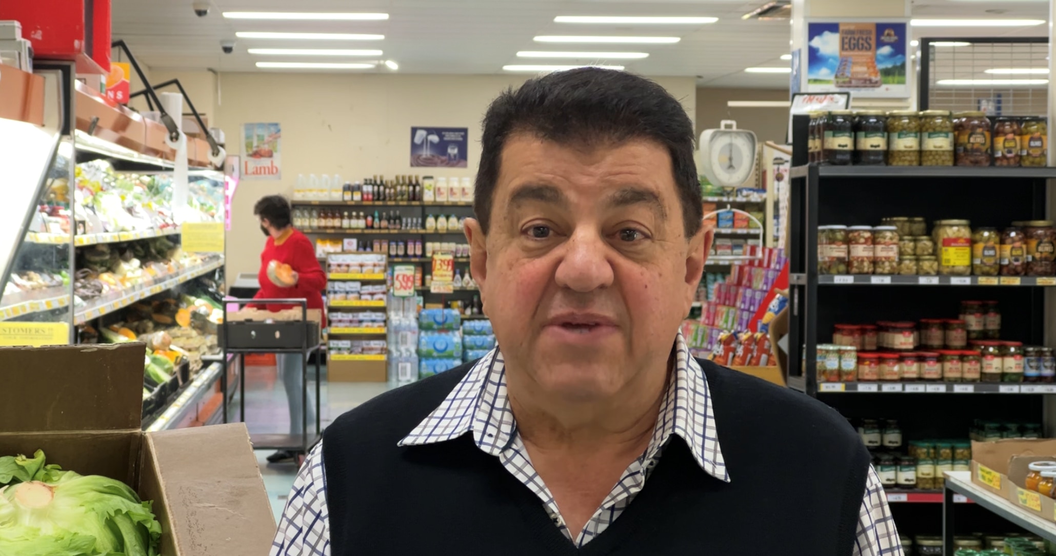 Man stars at camera with shopping shelves behind him
