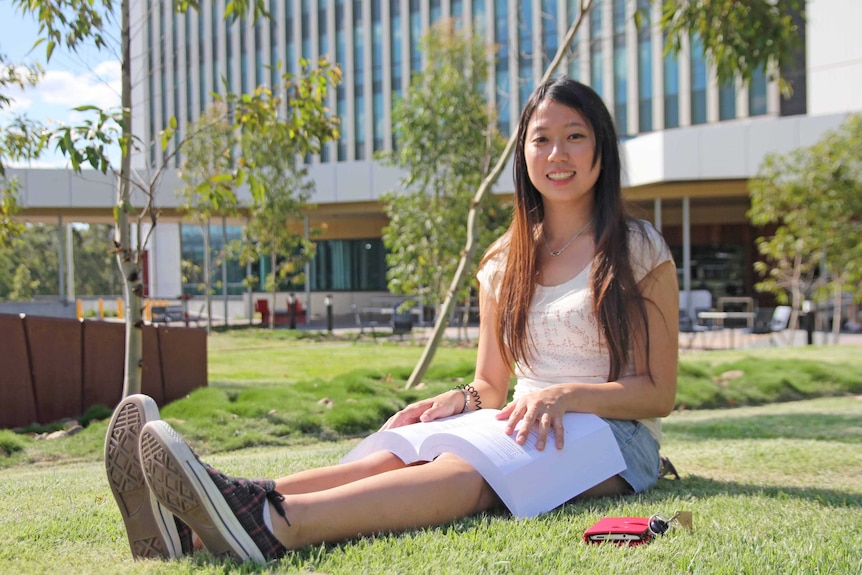 Gold Coast university student Kristy Lo sits outside reading a textbook, January, 2015