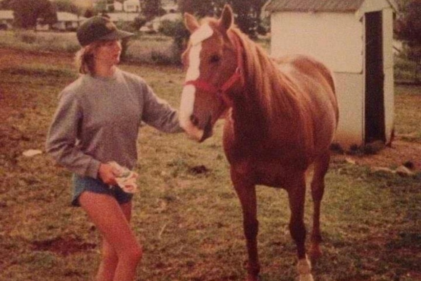 A young woman is pictured with a horse in an old supplied photo.