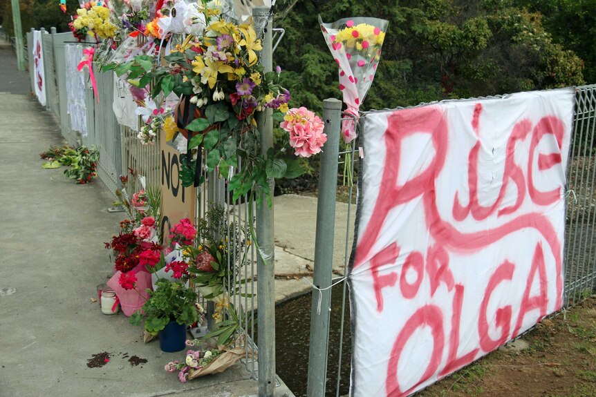 Floral tributes and a sign "Rise for Olga" have been set up at the scene of a murder in Hobart.