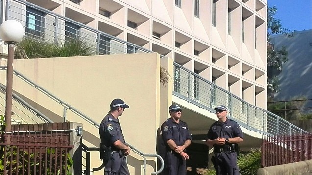 Police officers stand guard outside Newcastle District Court.