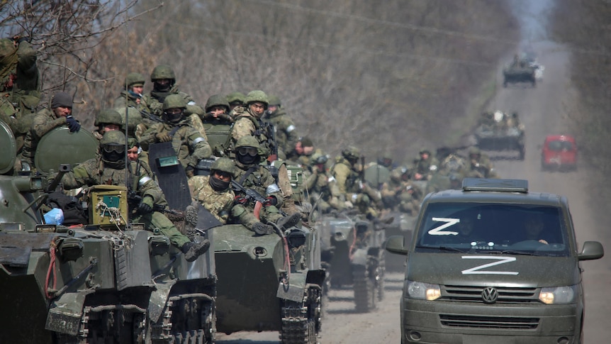 Service members of pro-Russian forces ride on armoured vehicles 