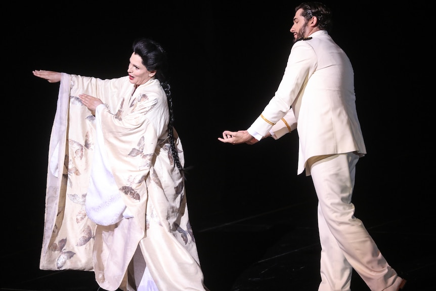 A woman in a Japanese traditional outfit and a caucasian man in a suit in a play.