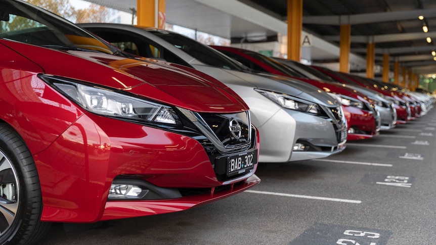 A row of cars parked under cover.