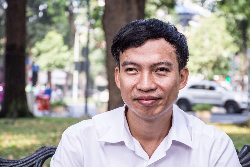 Portrait of Tran Van Giap on a park bench