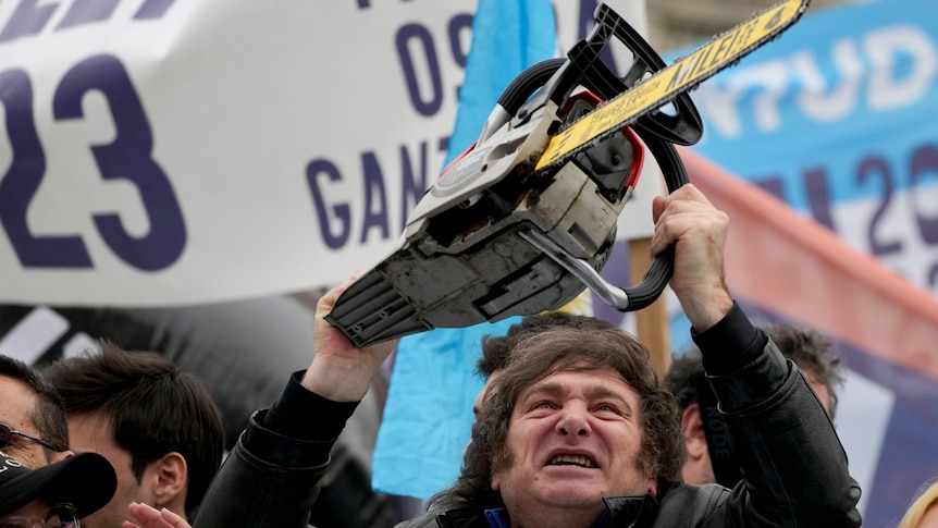 Javier Milei weilds a chainsaw above his head during a campaign rally.