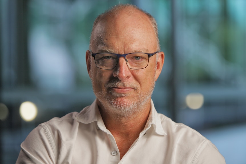 Man wearing a white shirt and glasses.