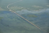 An aerial shot of a remote highway surrounded by floodwaters.