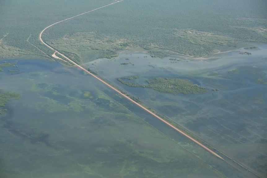 An aerial shot of a remote highway surrounded by floodwaters.