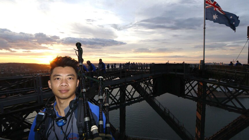 Man standing with his bagpipes on top of Sydney Harbour Bridge.