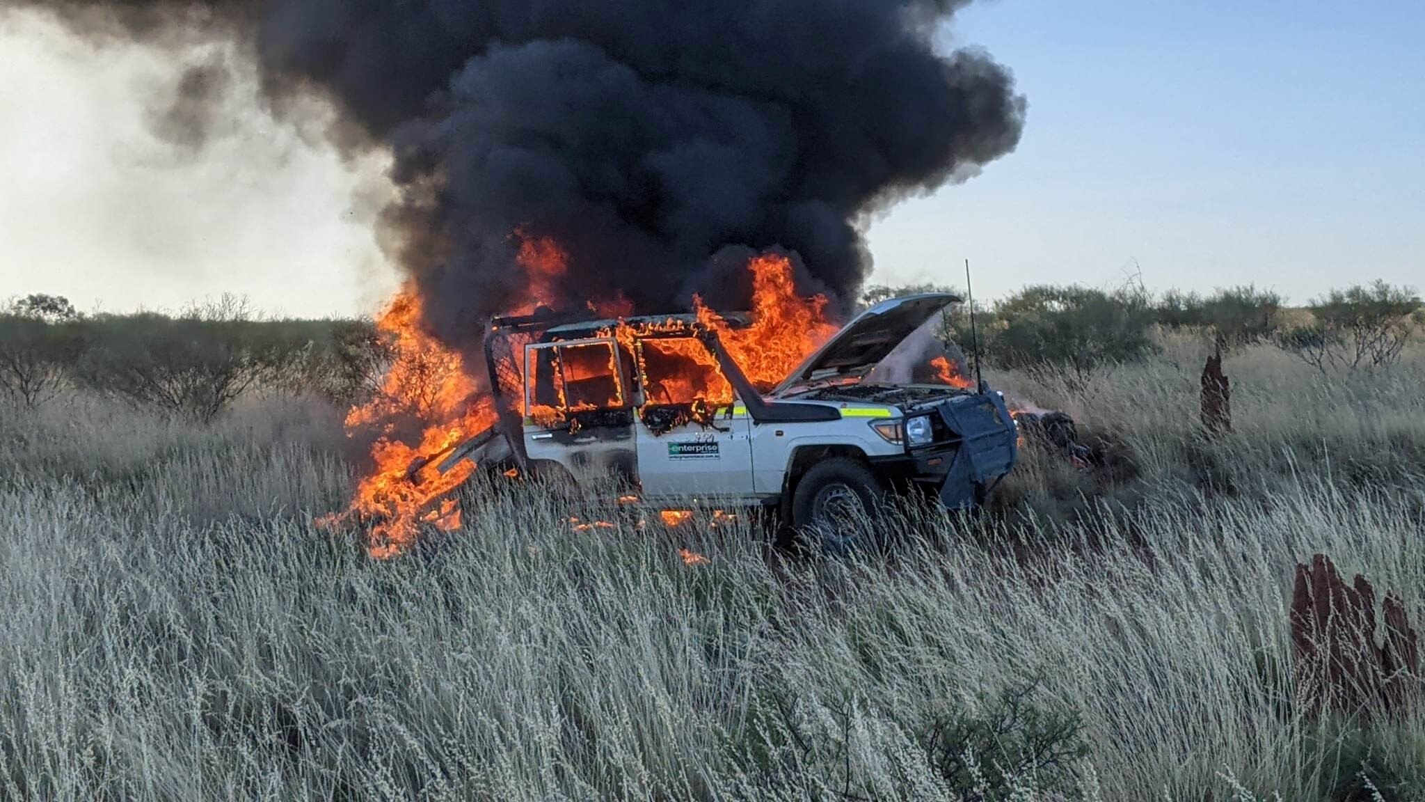 A burninig dual cab Toyota Land Cruiser in remote spinifex country near Balgo, Western Australia, 2023.