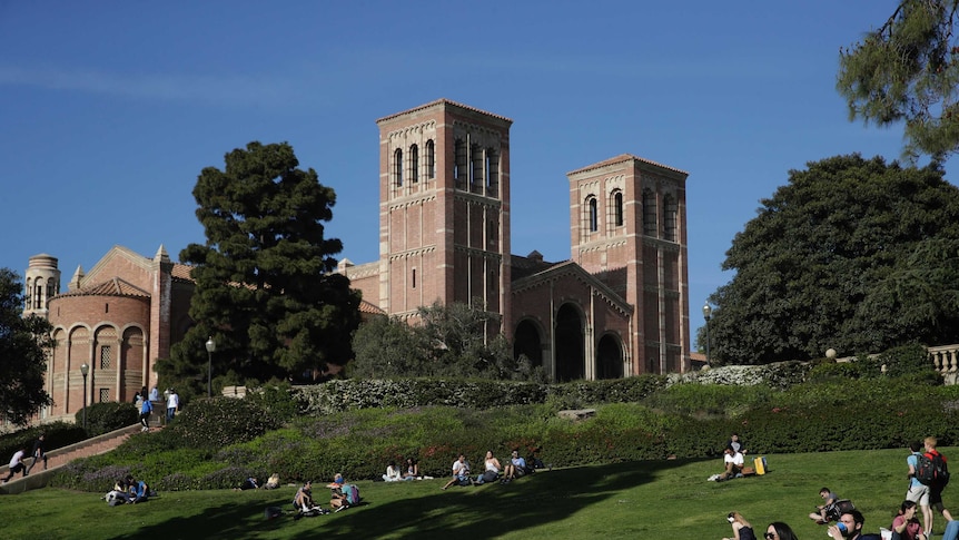 A gentle green hill hosts a number of UCLA students as you look up to a the university's Romanesque Royce Hall.