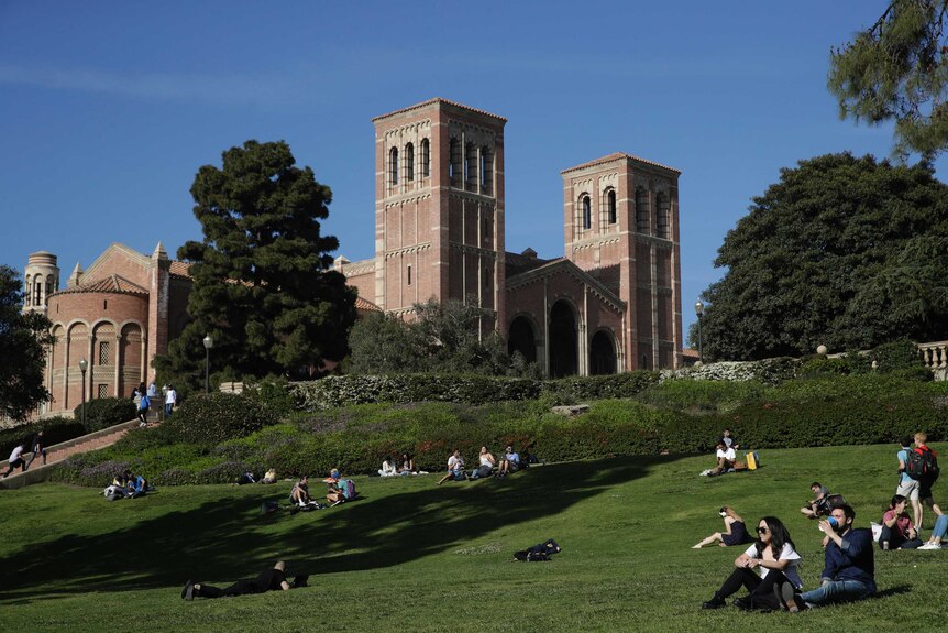 A gentle green hill hosts a number of UCLA students as you look up to a the university's Romanesque Royce Hall.