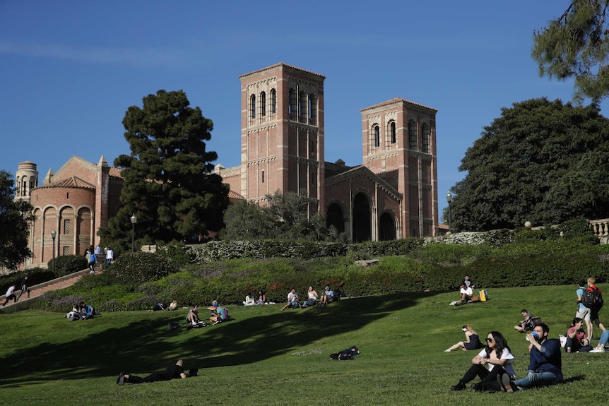 A gentle green hill hosts a number of UCLA students as you look up to a the university's Romanesque Royce Hall.