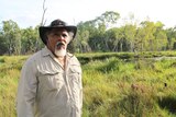 Traditional owner Adrian Burragubba stands at wetlands and trees near Adani's Carmichael coal mine site.