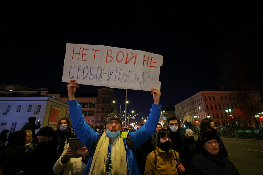 A man carries a banner, which reads "No war. Freedom for political prisoners", during an anti-war protest in Moscow