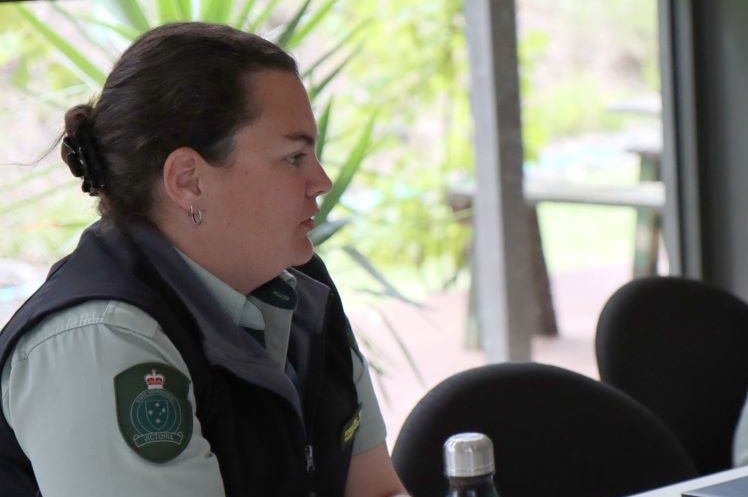 Jenny and Andrew sit around a meeting table. Both wear the green Forest Fire Management Victoria uniform.