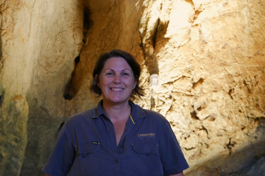 A woman standing in a cave.