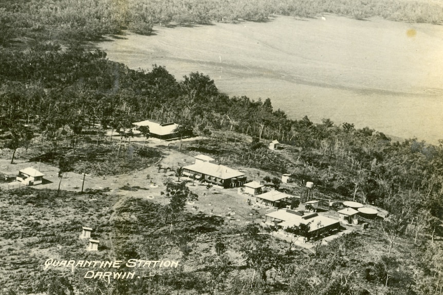 A historical black and white photo of a quarantine station on the coastline of Darwin Harbour.
