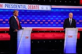 Joe Biden and Donald Trump stand on a debate stage.