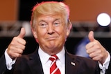 A close up of Donald Trump giving a smile with his thumbs up
