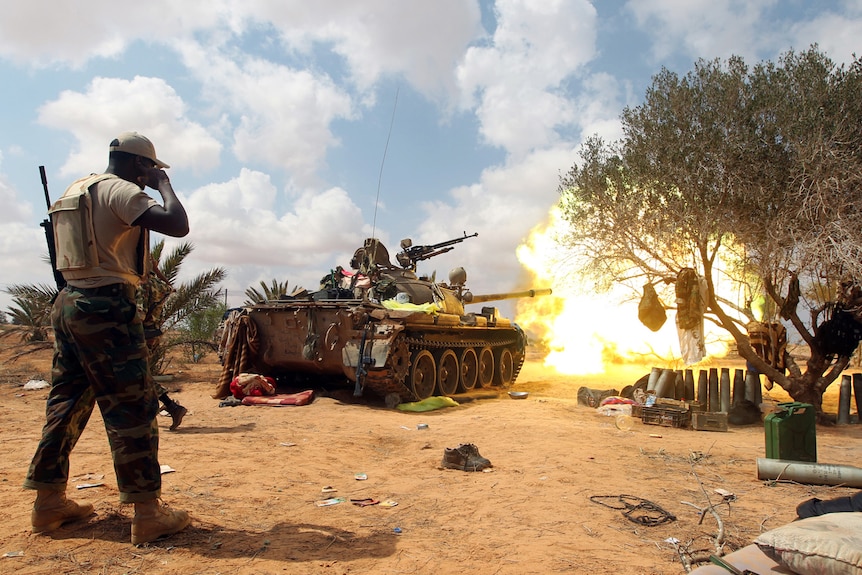 A Libyan National Transitional Council tank shells the city of Sirte some 5km east of the entrance to the city