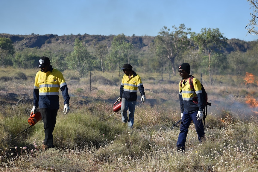 Indigenous rangers light fuel reduction fires.